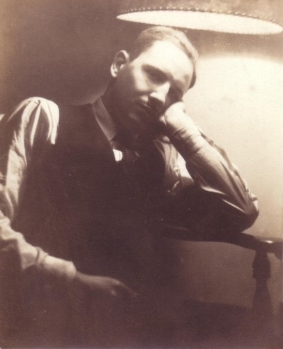 Laird Ahrens resting his chin on his hand under a lamp, sepia portrait, 1935