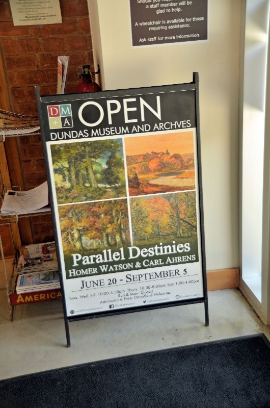 Event poster featuring work by Carl Ahrens and Homer Watson