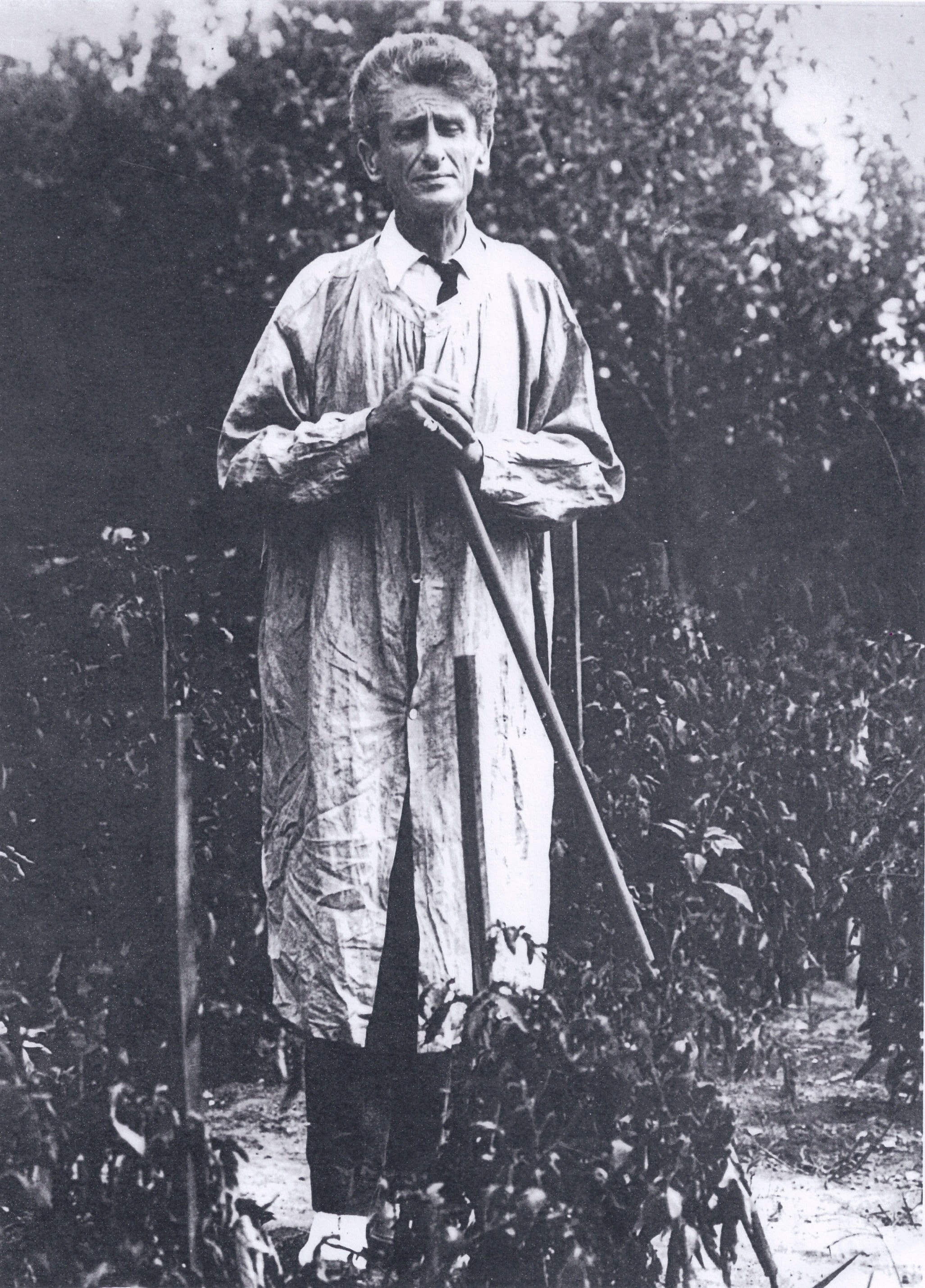 Carl Ahrens standing in his garden with a gardening tool