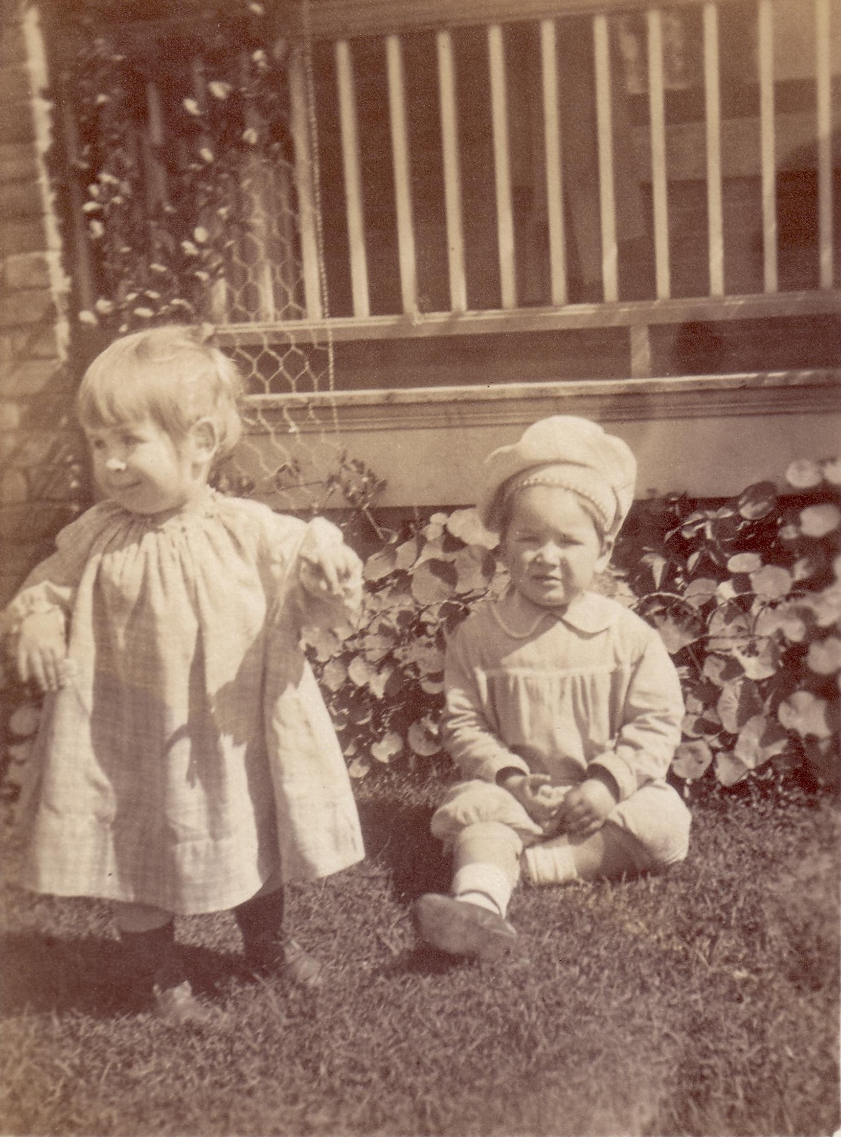 Laird and Penelope playing together in a garden